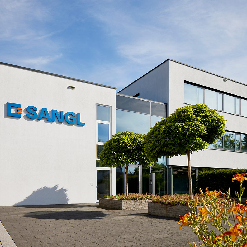 Sangl main building with company logo and flowering garden in the foreground