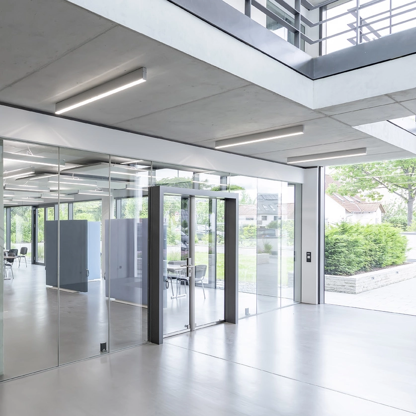 Entrance area at Sangl with glass partition doors and a view of the garden through floor-to-ceiling windows